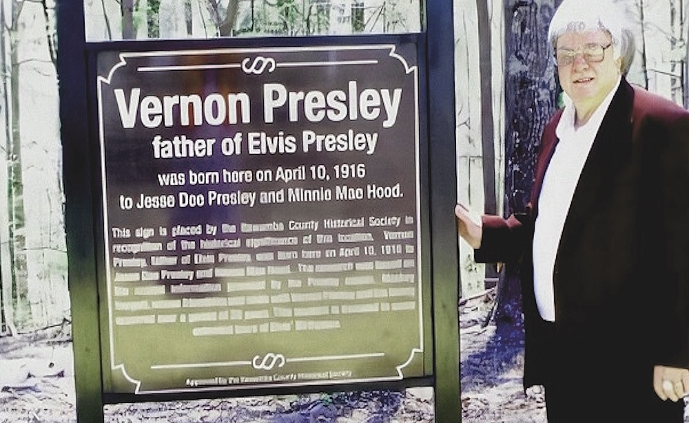 Mackey with sign at Vernon's birthplace